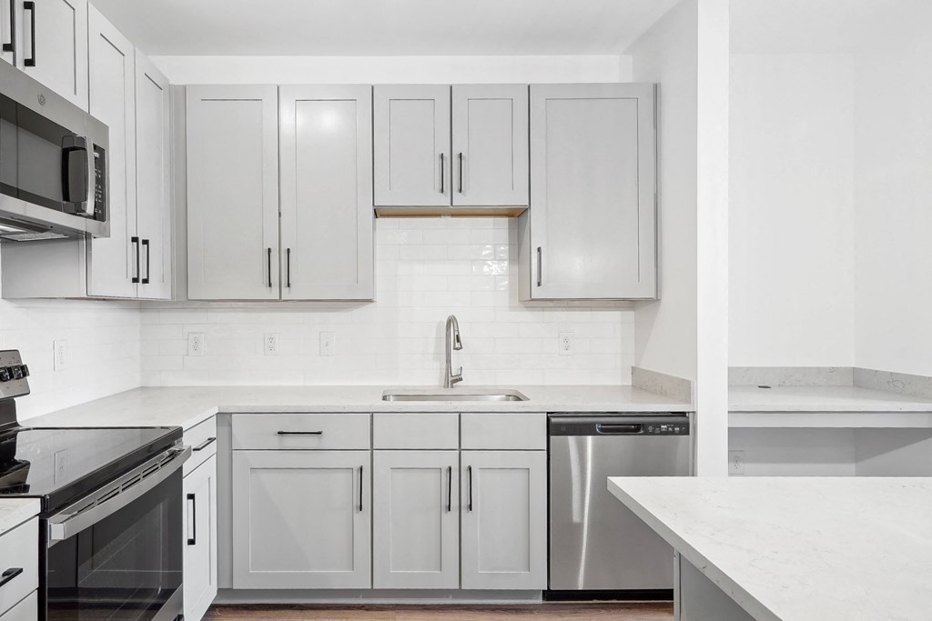 an all white kitchen with white cabinets and white counter tops