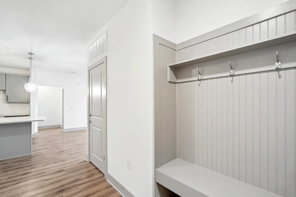 a renovated living room and kitchen with white walls and wood floors