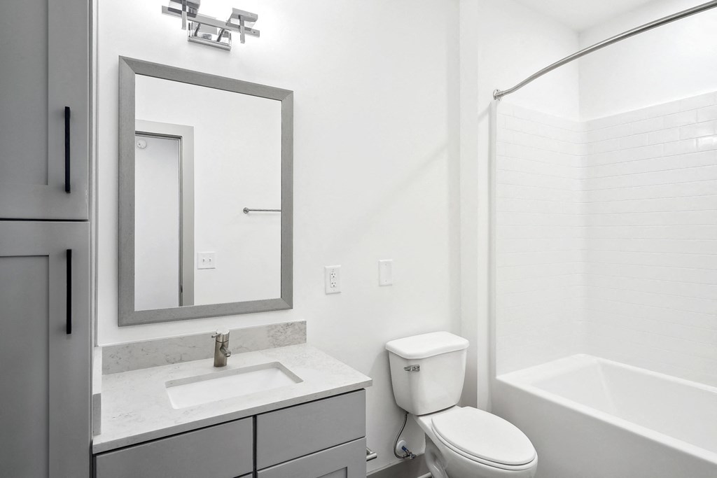 a bathroom with a sink toilet and a mirror