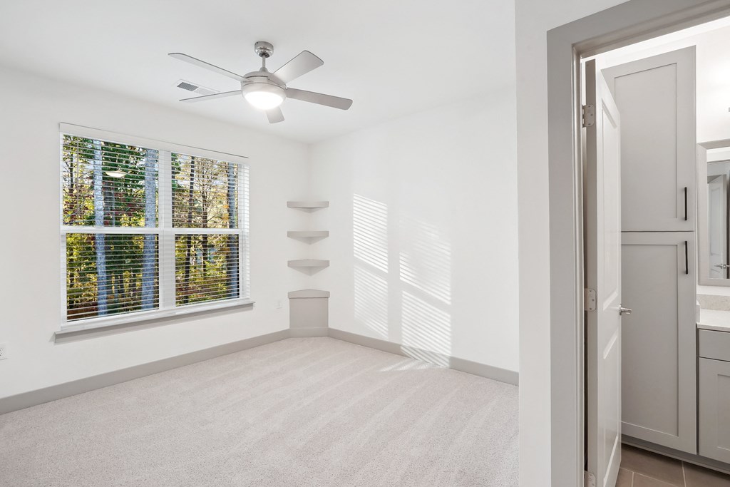 a living room with a large window and a ceiling fan