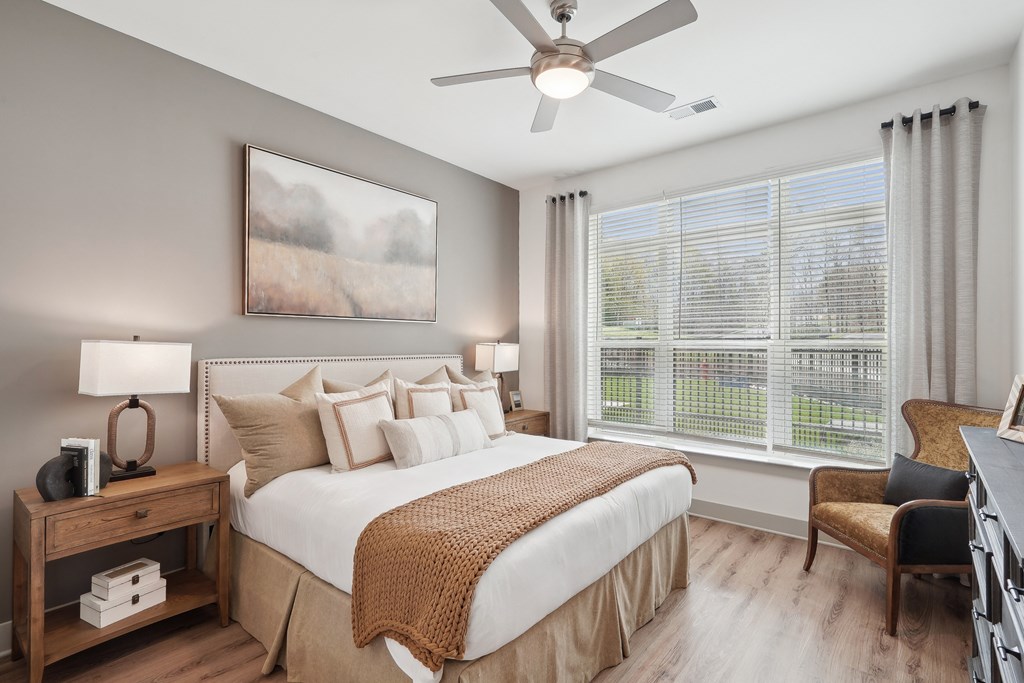 a bedroom with a large bed and a ceiling fan