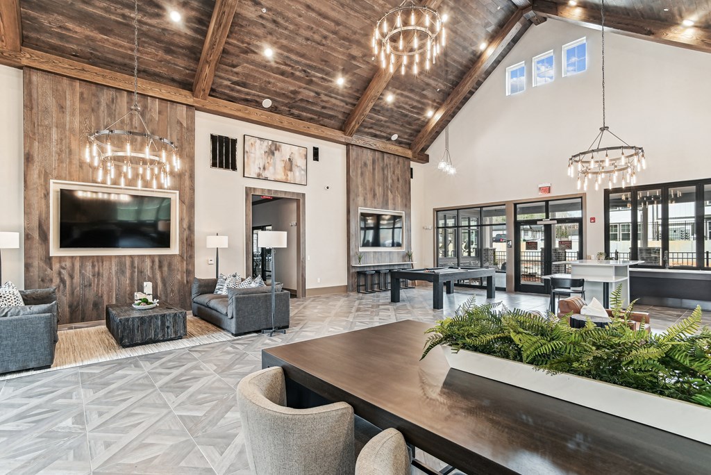 a large lobby with a table and chairs and a television