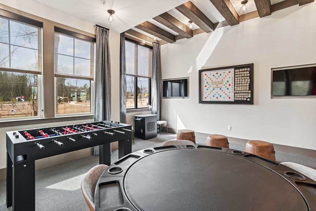 a game room with a table with chairs and a foosball