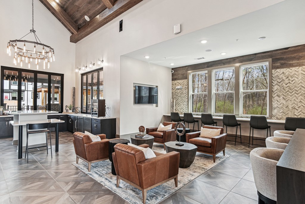 a lobby with couches chairs and tables and a bar with a television
