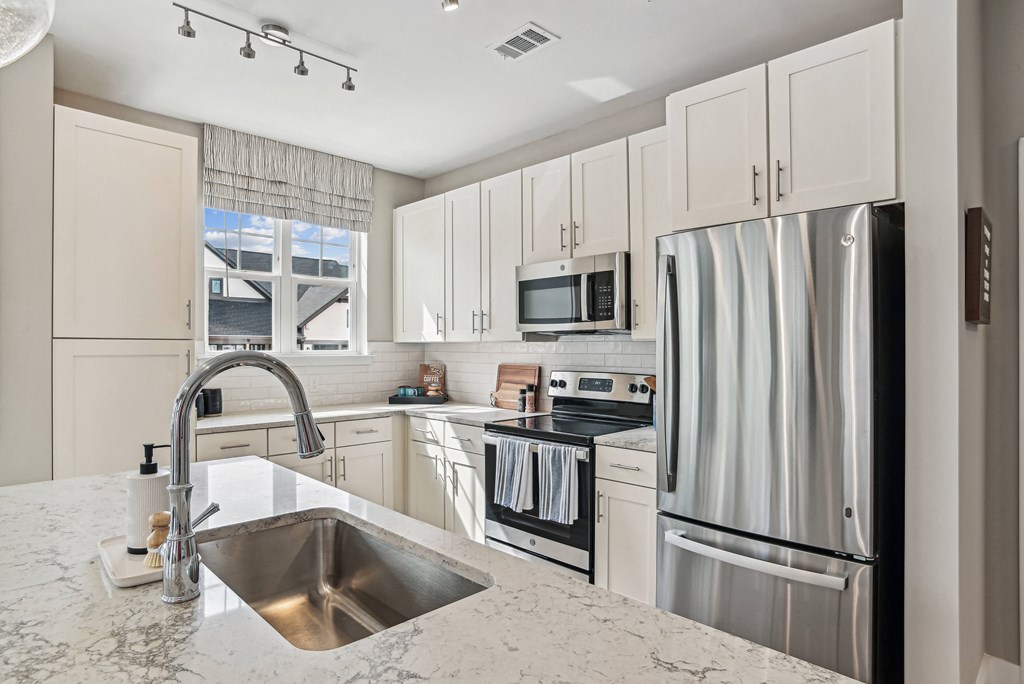a kitchen with stainless steel appliances and white cabinets