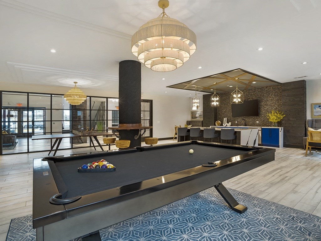 A pool table is in the middle of a room with a blue carpet.