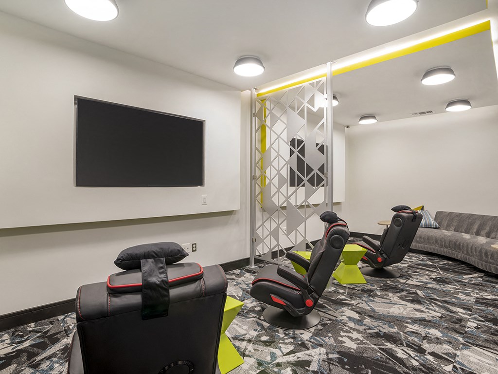 A room with a black screen and chairs.