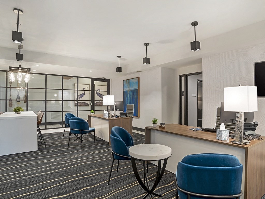 A modern office space with blue chairs and a white reception desk.