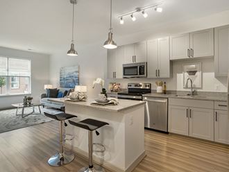 an open kitchen and living room with a bar and stools