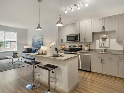 A modern kitchen with a bar stool in front of the island.