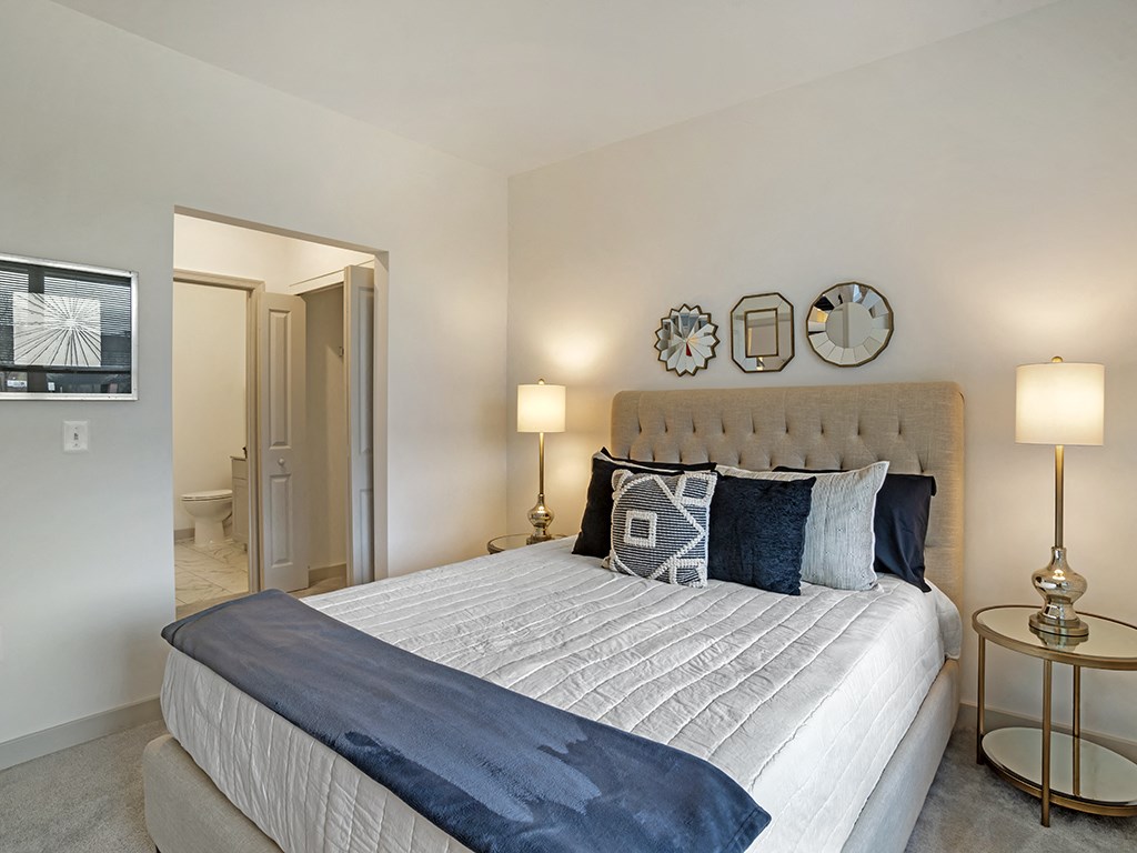 A bedroom with a large bed and a mirror above it.