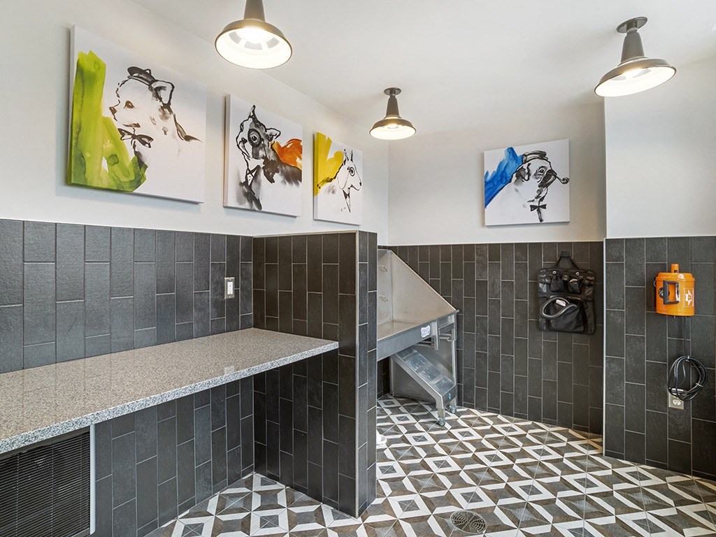 Bathroom with grey tiles and artwork on the wall.