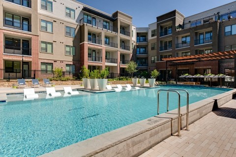 A large swimming pool in front of apartment buildings.