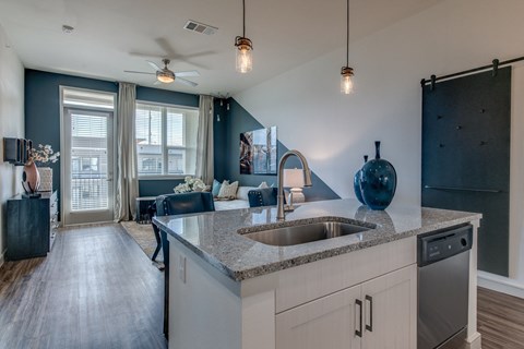 A modern kitchen with a dark blue vase on the counter.