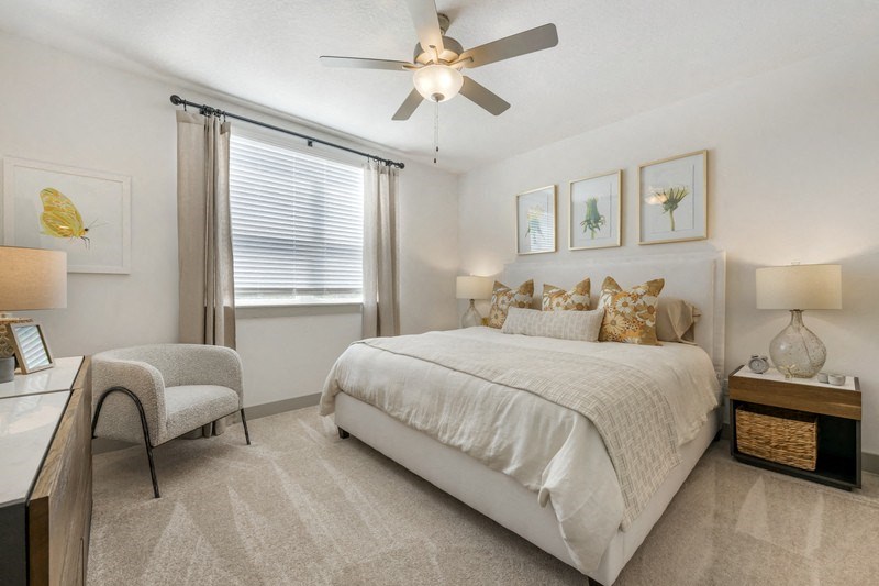 a bedroom with a ceiling fan and a window