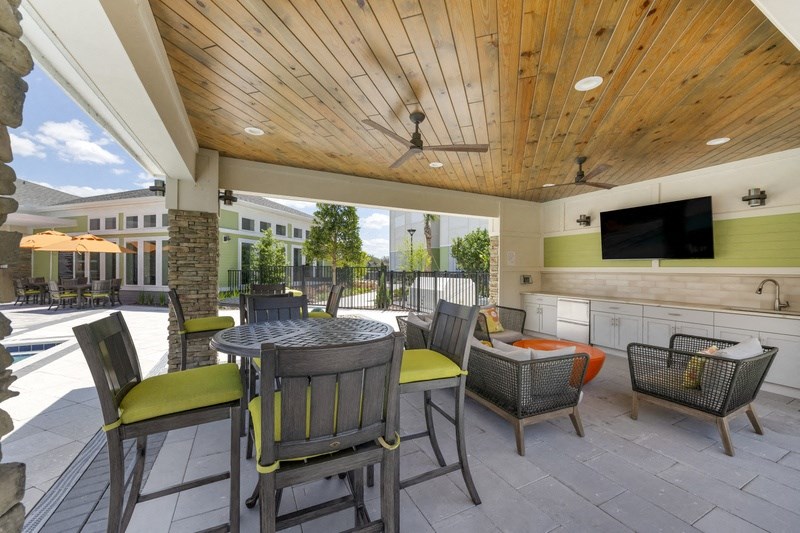 a patio with a table and chairs and a tv on the wall