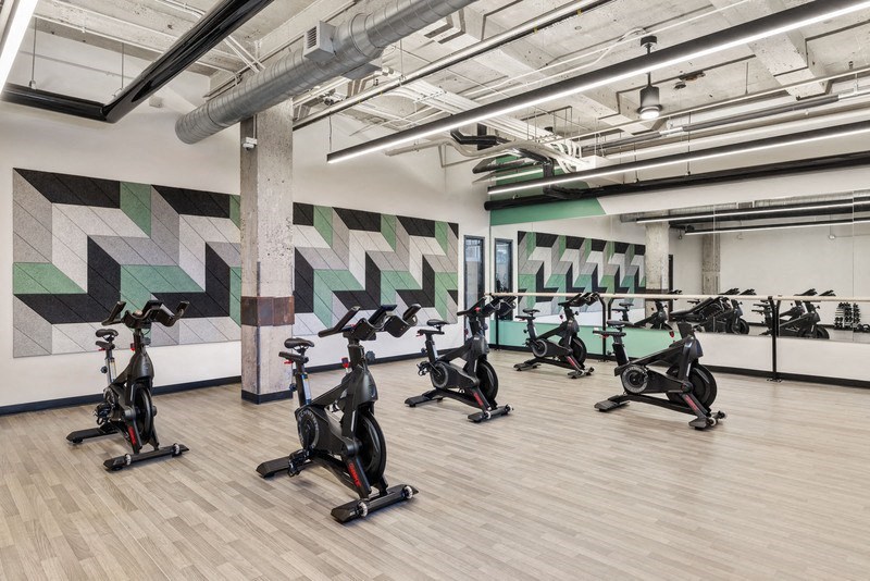 a group of people riding on exercise bikes in a room