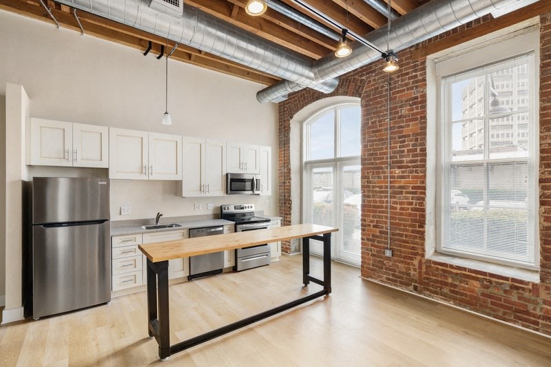 an open kitchen with a large window and a wooden table