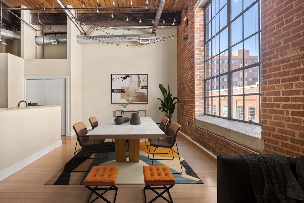 a room with a table and chairs and a large window
