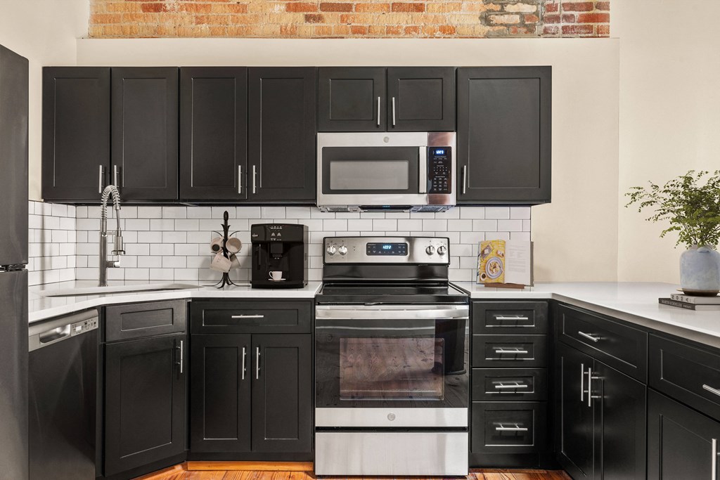 a kitchen with black cabinets and white countertops