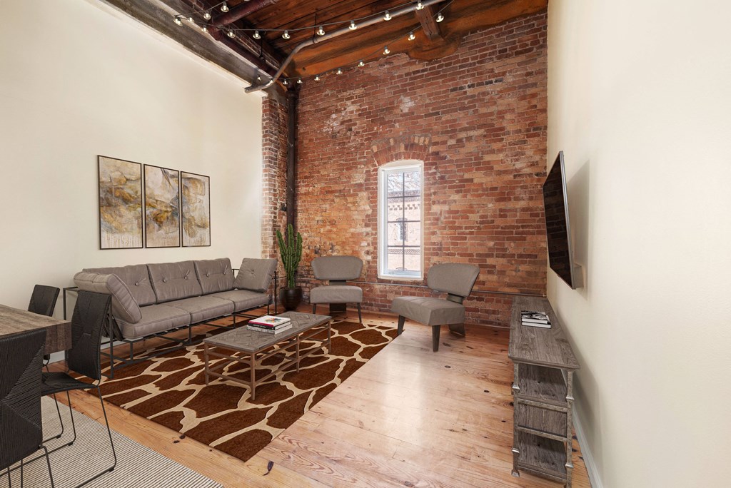 a living room with exposed brick walls and a large window