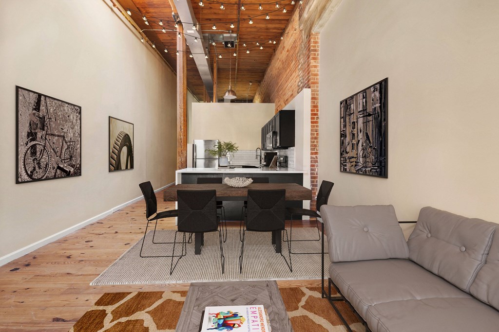 a dining area with a table and chairs and a kitchen in the background