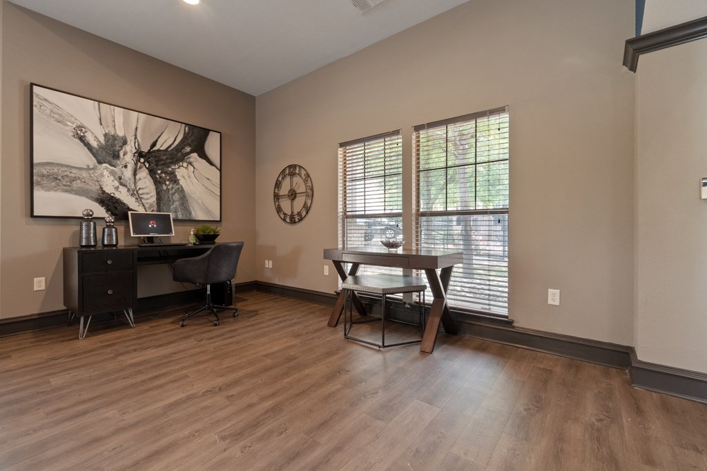 an office with a desk and a chair and a large window