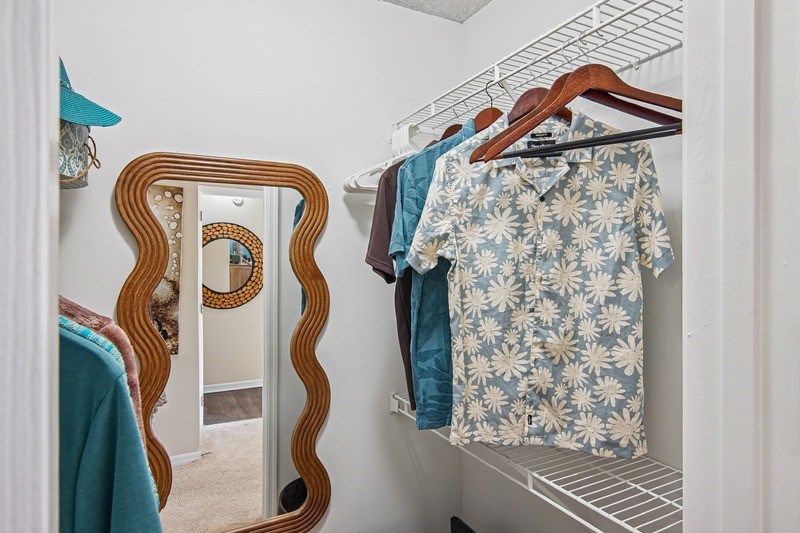 A closet with mirror with a wooden frame is leaning against a wall.