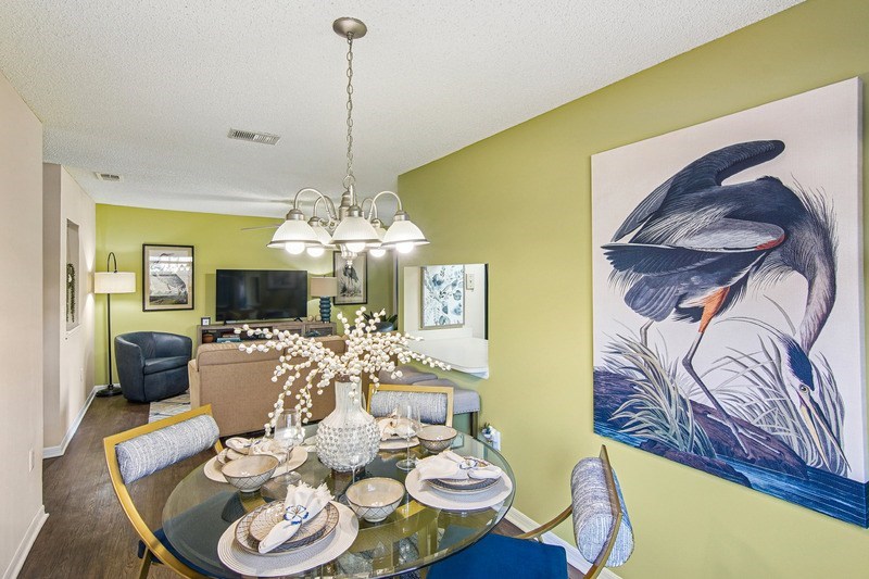 A dining room with a glass table set for a meal.