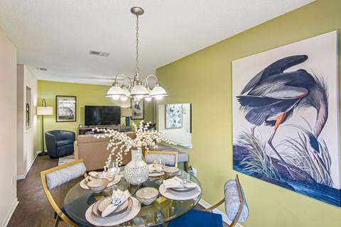 A dining room with a glass table set for a meal.