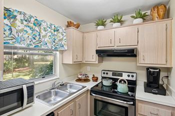 A kitchen with a microwave, sink, stove, and oven.