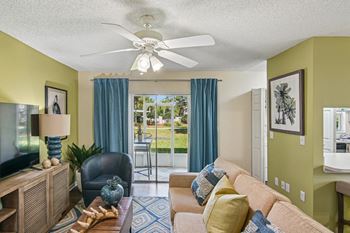 A living room with a couch, chair, and television.