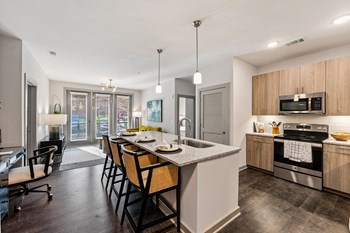 kitchen with light wood cabinets and barstools - Photo Gallery 3