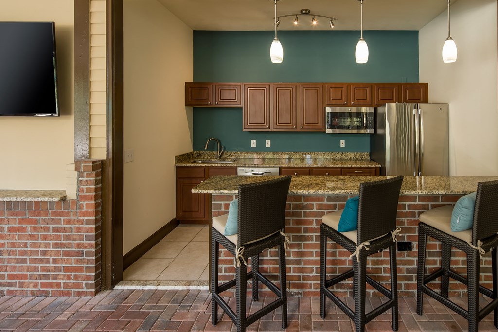 a kitchen with a bar and a stainless steel refrigerator