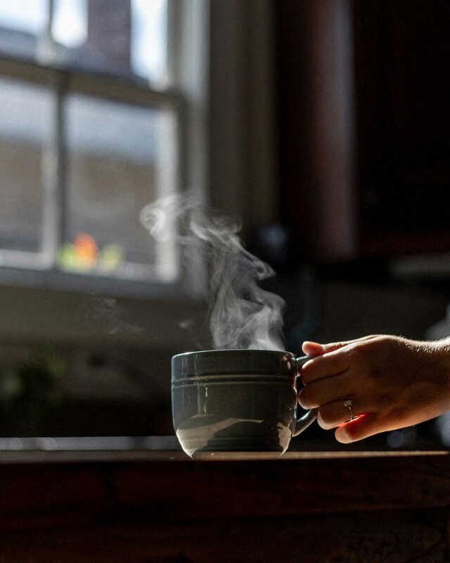 a person holding a coffee cup with steam coming out of it