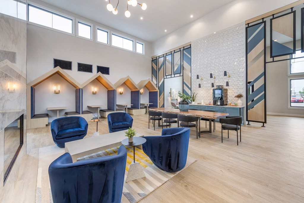 a living room with blue chairs and tables and a fireplace