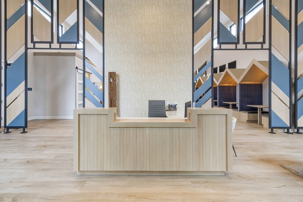 a reception desk in front of a lobby with desks and chairs