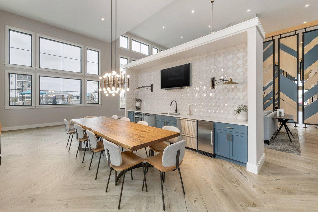 a dining room with a wooden table and chairs and a kitchen with blue cabinets