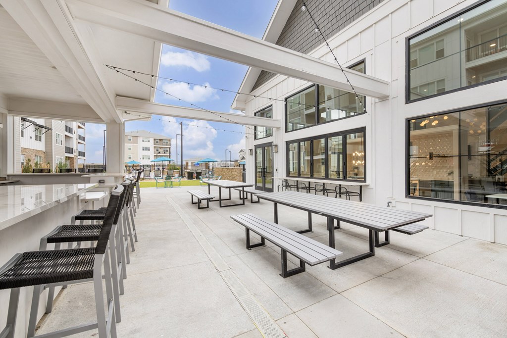 a patio with benches and tables outside of a building