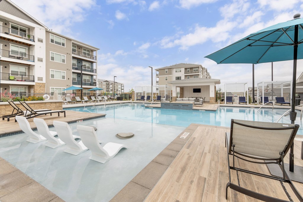 our apartments have a large swimming pool with chairs and an umbrella