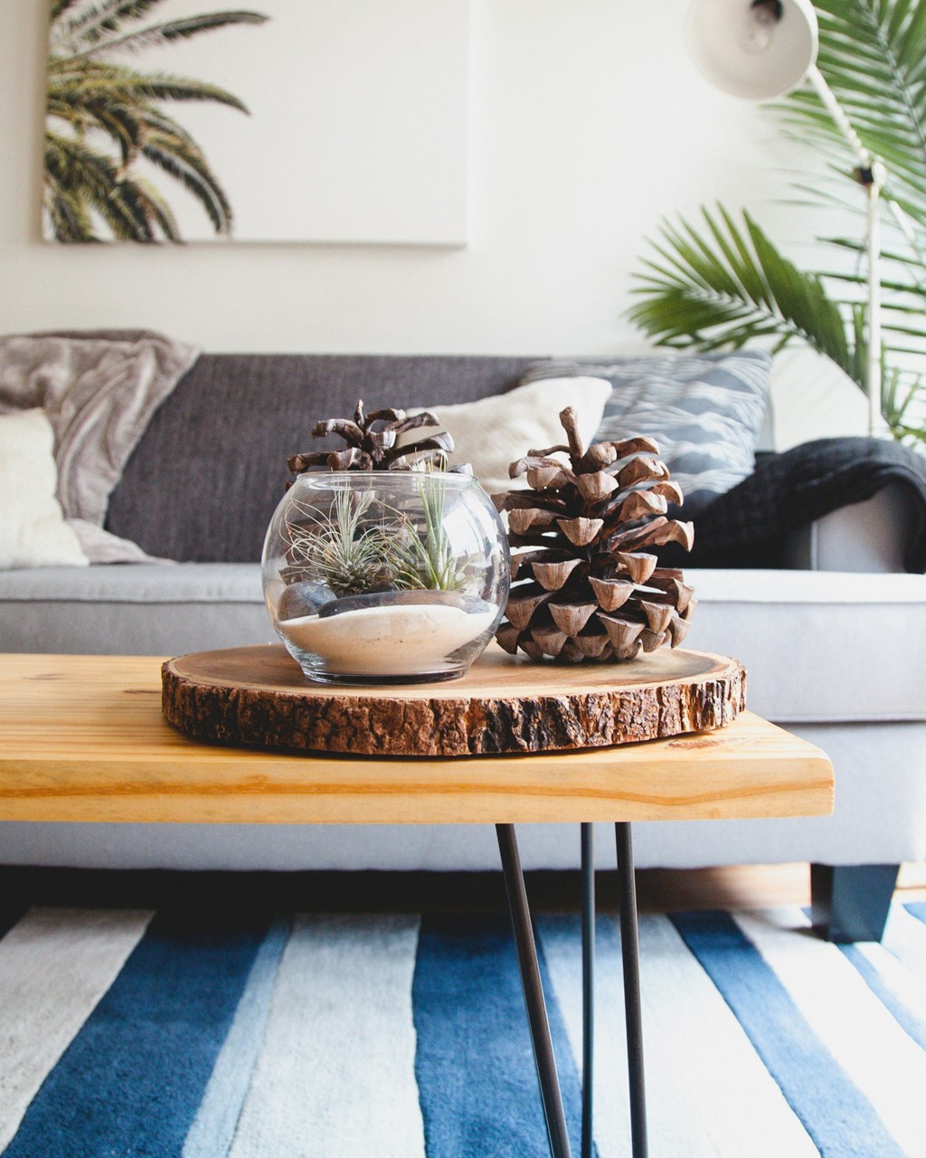 a living room with a wooden coffee table with a glass vase with a plant
