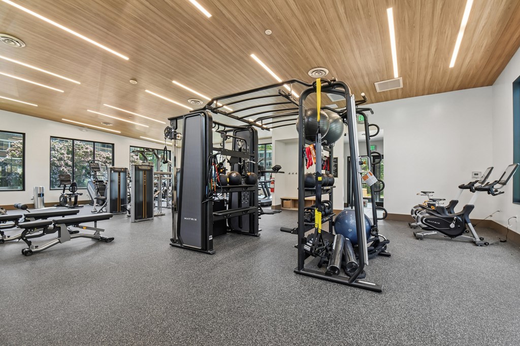 A gym with a variety of equipment including a weight machine, a bench press, and a rowing machine.
