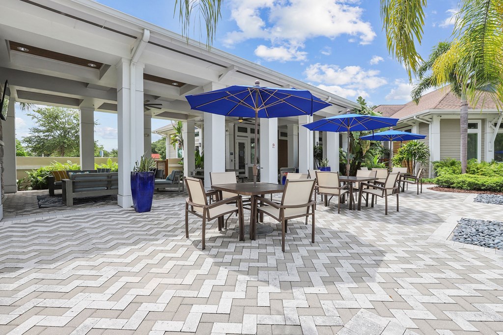 a patio with tables and chairs and umbrellas