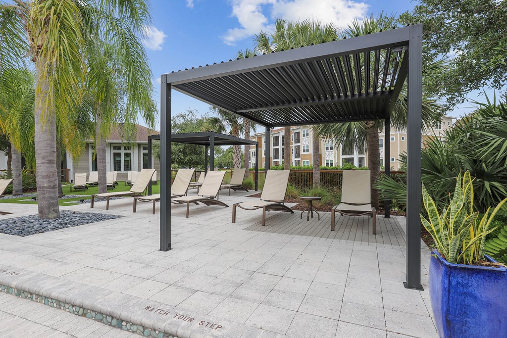 a covered patio with chairs and a pergola