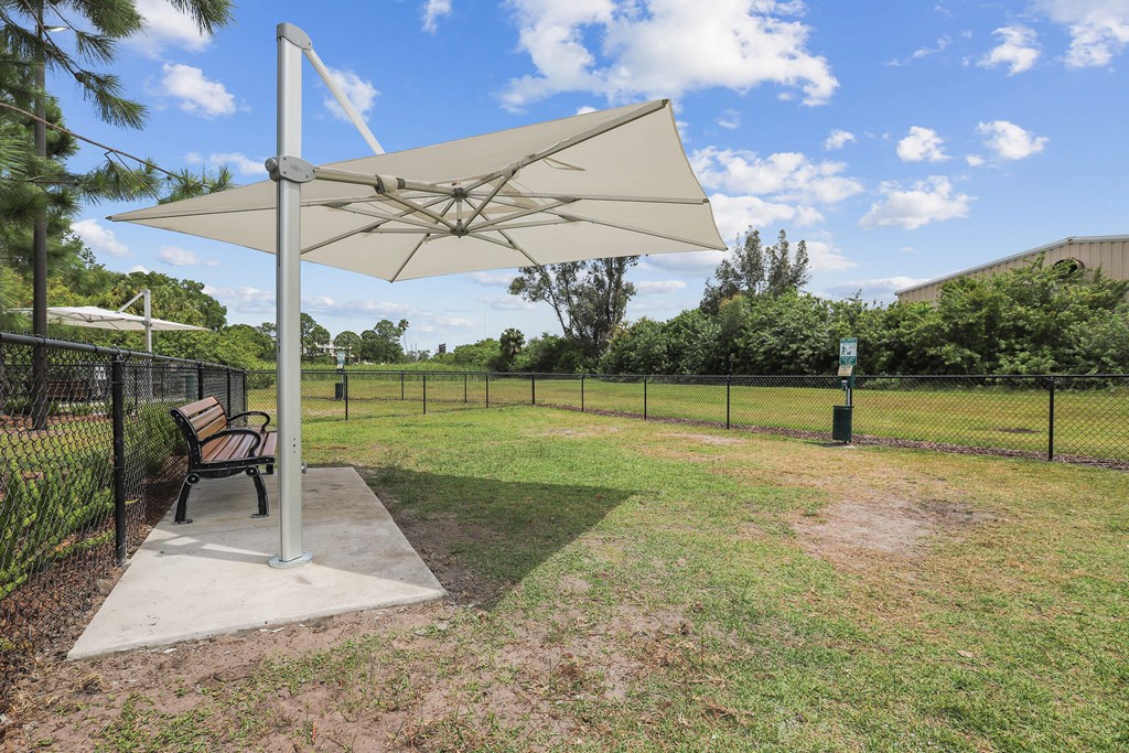 a park bench sitting under an umbrella in a yard
