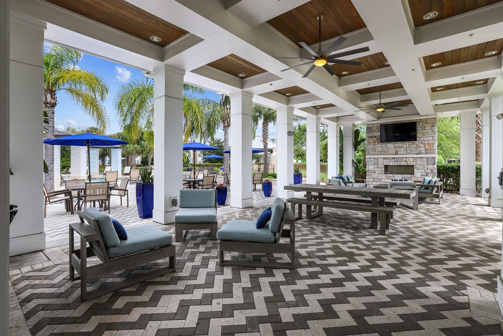 a patio with a fireplace and chairs and tables