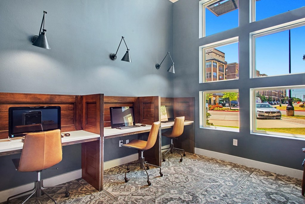 a business center with two desks and a window with a street view