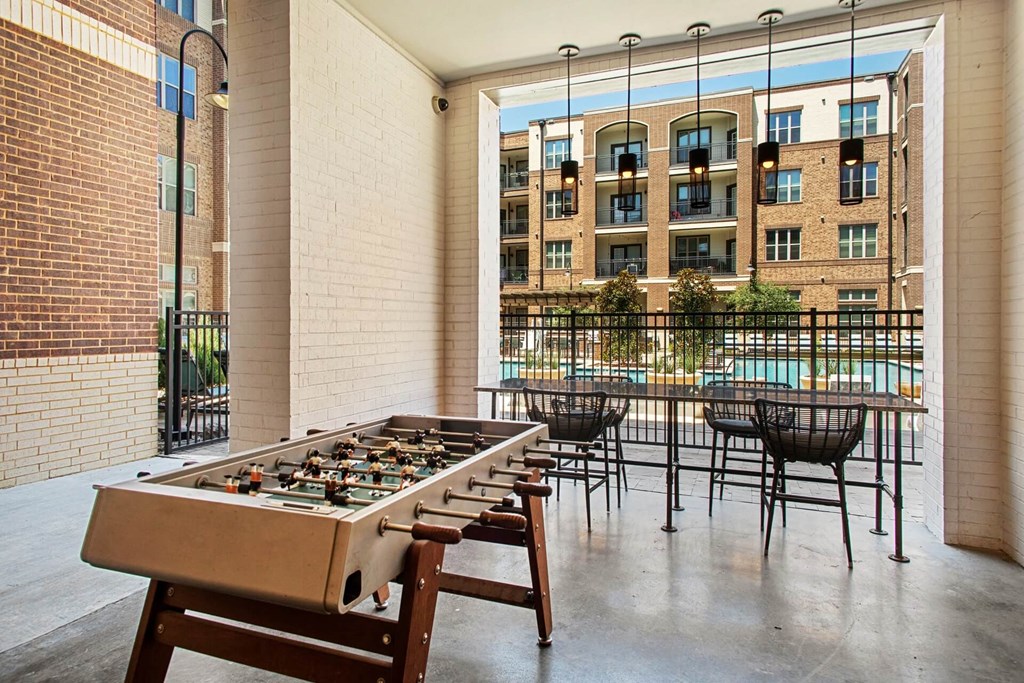 a games room with a foosball table and chairs in front of a pool