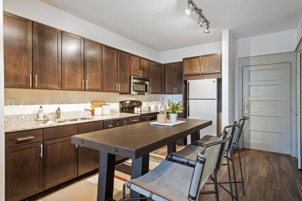 a kitchen with wooden cabinets and a table with chairs
