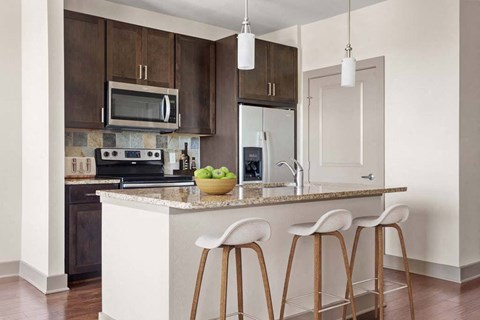 a kitchen with a counter with three stools